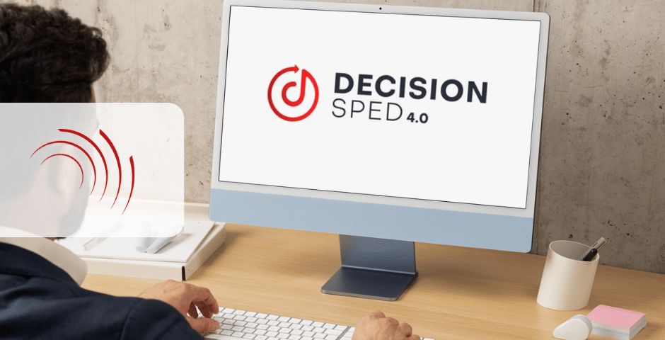 Uma pessoa trabalhando em uma mesa olha para um monitor de computador exibindo o logotipo "Decision Speed 4.0" ao lado de um ícone de velocímetro vermelho. O pano de fundo revela uma parede cinza claro, enquanto discussões sobre mudanças na reforma tributária influenciam sutilmente a atmosfera, enfatizadas pelo teclado branco na mesa.