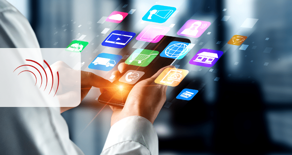 Uma pessoa usa um smartphone com ícones coloridos de aplicativos flutuando acima da tela, representando diversos serviços digitais e ferramentas de comunicação dentro do sistema tributário. O fundo desfocado enfatiza a tecnologia em uso.