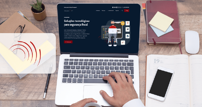 Uma pessoa digita em um laptop que exibe um site sobre soluções tecnológicas para segurança fiscal e tributação no destino. Nas proximidades estão um notebook, um smartphone, uma xícara de café, fones de ouvido, um mouse e um pequeno vaso de plantas em uma mesa arrumada.