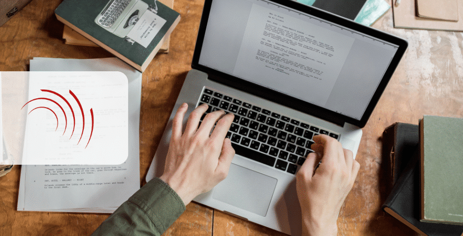 Uma pessoa digita em um laptop em uma mesa de madeira cercada por livros e papéis, possivelmente preparando uma Declaração de Regimes Específicos. Um gráfico transparente com linhas curvas vermelhas está sobreposto no lado esquerdo da imagem.