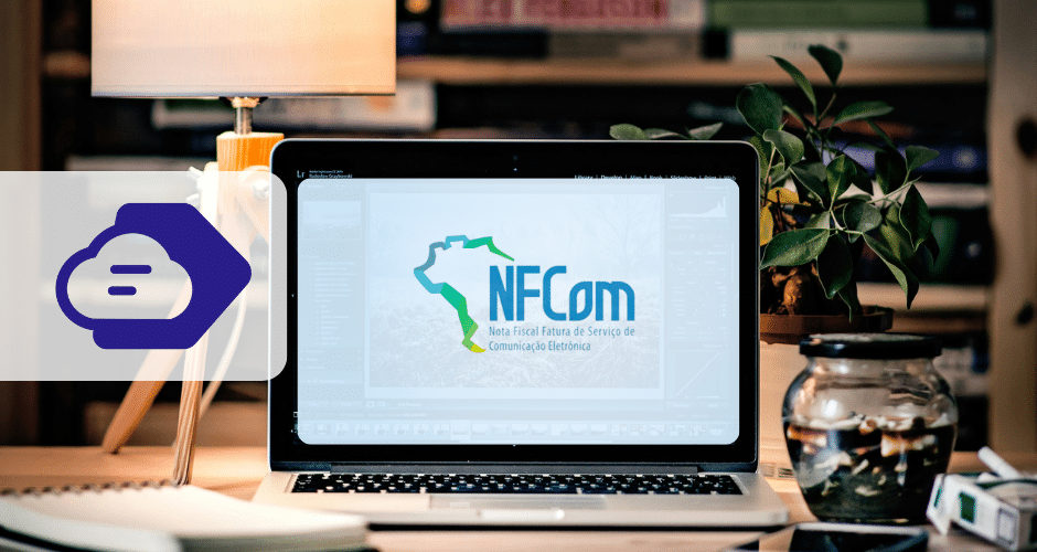 Um laptop em uma mesa exibe o logotipo da NFCom, com um mapa do Brasil e um texto sobre a Obrigatoriedade NFCom. Ao lado do laptop, há uma planta, uma vela e material de escritório. Um ícone abstrato de nuvem está sobreposto no lado esquerdo da imagem.