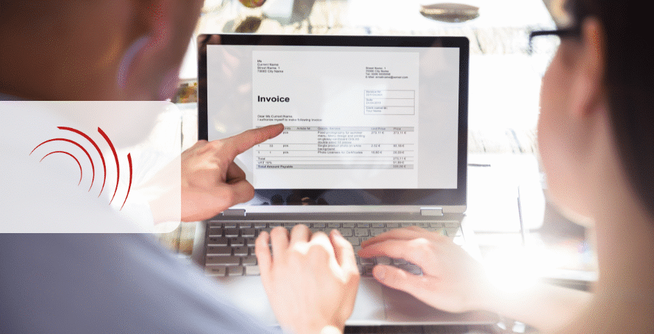 Uma pessoa aponta para uma fatura rotulada como NFSe Nacional exibida na tela de um laptop enquanto outra usa o teclado, sugerindo uma discussão ou revisão do documento da fatura.