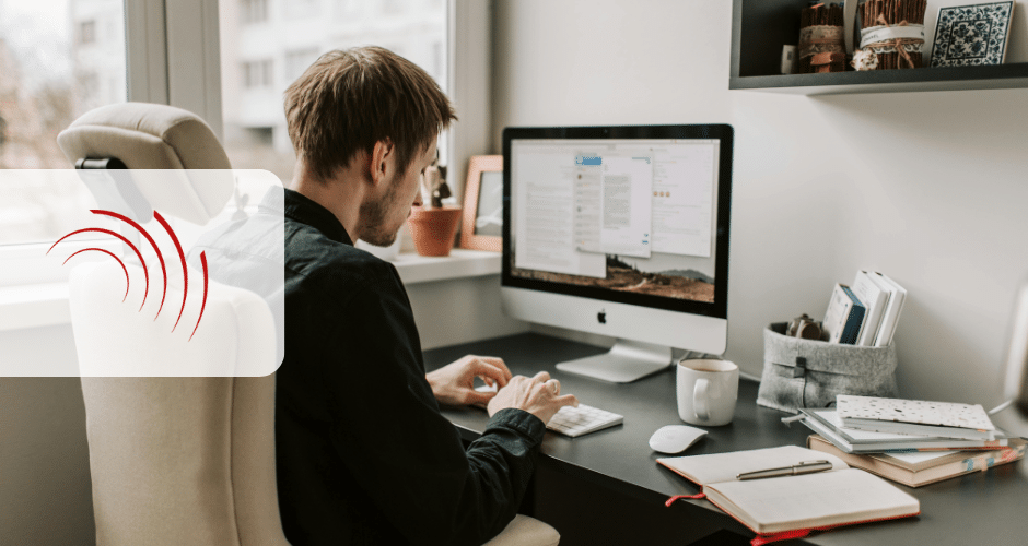 Uma pessoa digita em um teclado em uma mesa com um grande monitor de computador, livros e uma caneca de café em um escritório residencial moderno e bem iluminado. Um logotipo vermelho com linhas curvas e o texto "restituição do IBS e da CBS" está sobreposto no lado esquerdo.